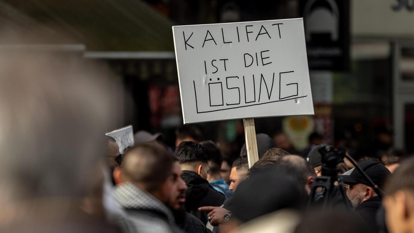 Bewusste Provokation: Teilnehmer einer Islamisten-Demo halten in Hamburg ein Plakat mit der Aufschrift "Kalifat ist die Lösung" in die Höhe.
