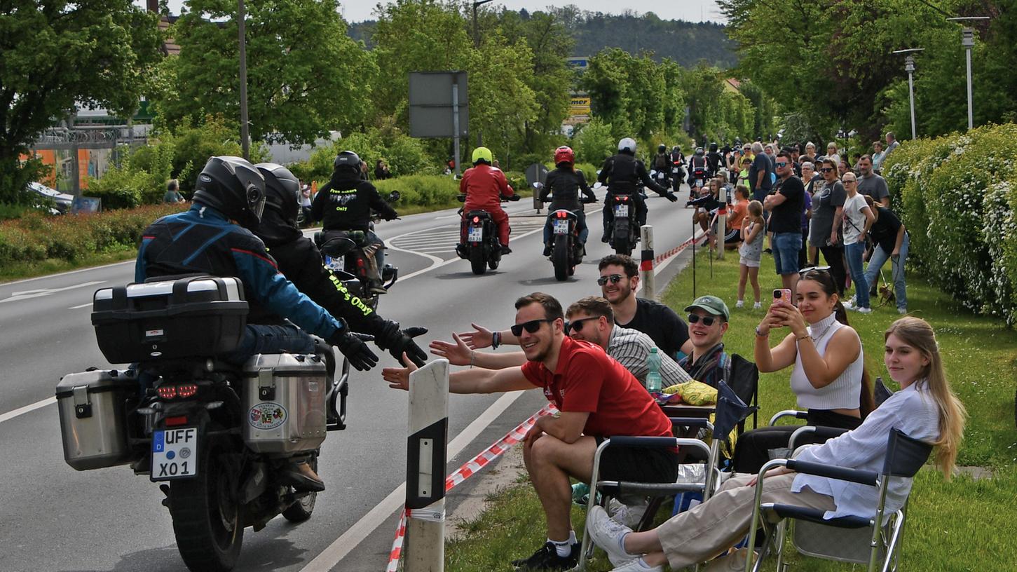 Motorradfahrer klatschen in Schwarzenbruck mit Zuschauern ab.