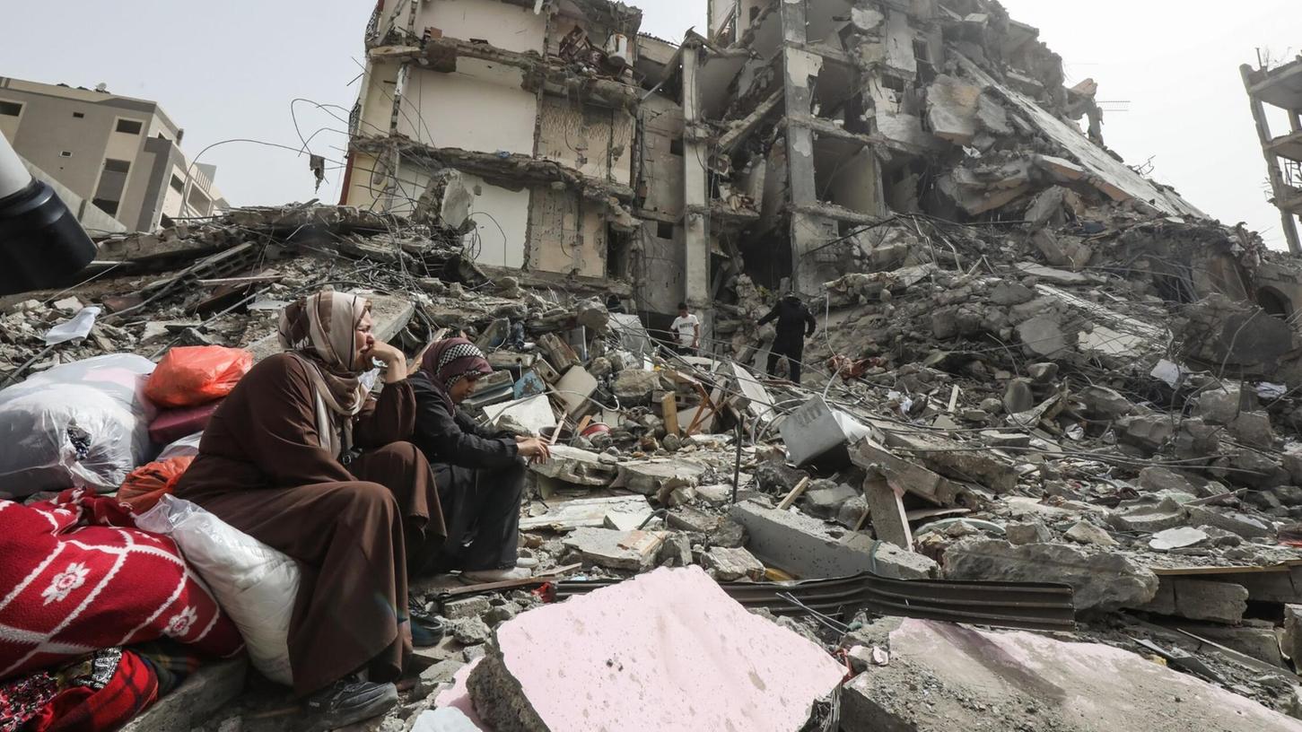 Palästinenserinnen sitzen auf Trümmern im Flüchtlingslager Nuseirat im Gazastreifen nach dem Abzug der israelischen Streitkräfte (IDF).