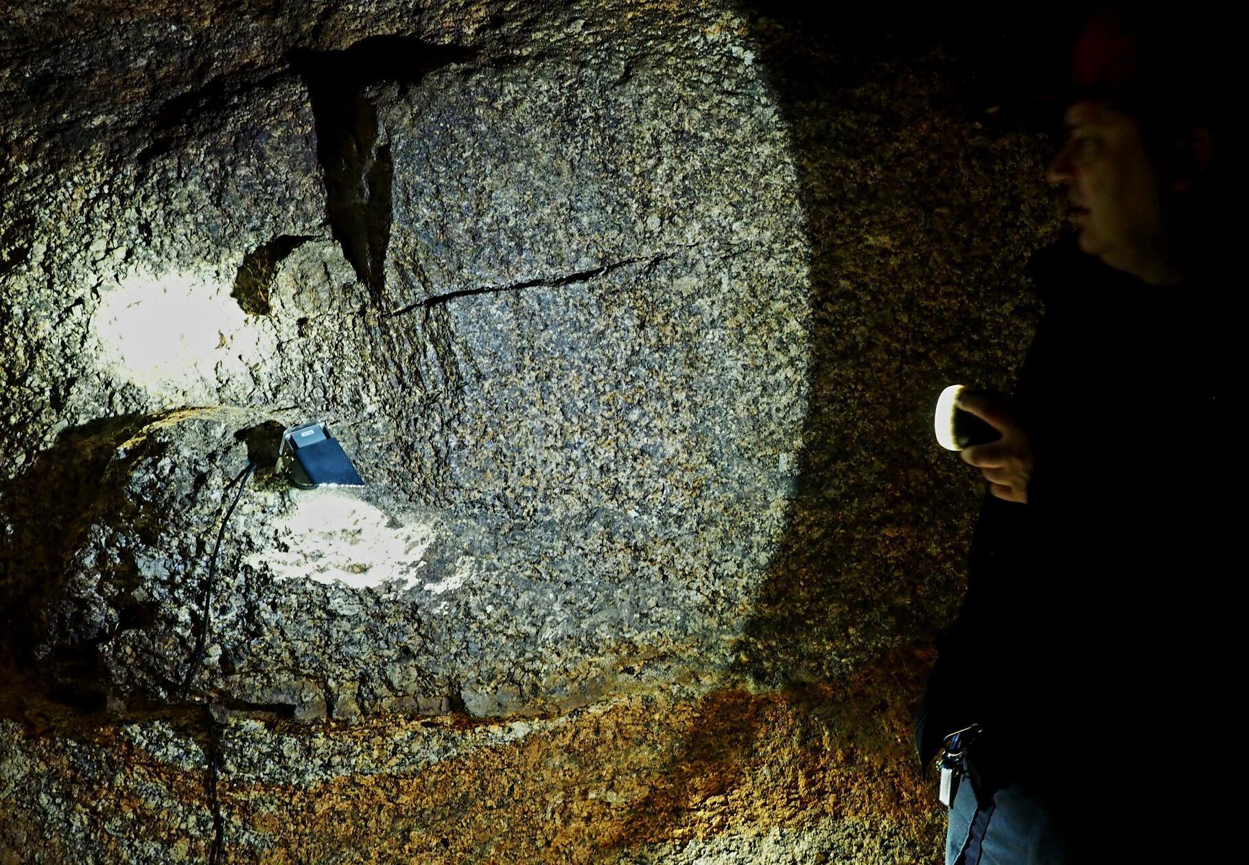 Im Gleißinger Fels wurde Eisenerz abgebaut - hier zeigt der Gästeführer den Glimmer im Fels.