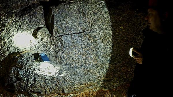 Im Gleißinger Fels wurde Eisenerz abgebaut - hier zeigt der Gästeführer den Glimmer im Fels.