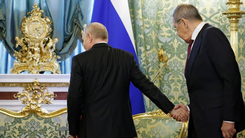 Der russische Präsident Wladimir Putin (l) gibt dem russischen Außenminister Sergej Lawrow die Hand, als dieser zu einem Treffen mit dem kubanischen Präsidenten Diaz-Canel im Großen Kremlpalast eintrifft.