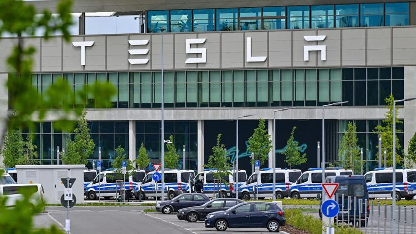 Polizeifahrzeuge stehen am Samstagvormittag vor dem Haupteingang des Tesla-Werks in Grünheide.