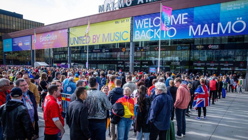 Musikfans stehen vor Beginn des Finales des Eurovision Song Contest 2024 vor der Malmö Arena.