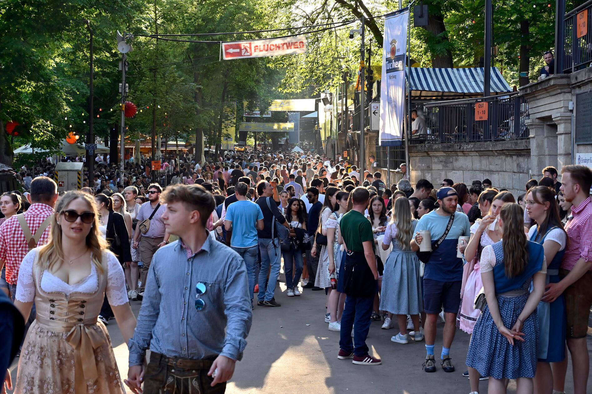 Erlangen: An Pfingstmontag pilgern nicht nut die Erlanger auf die Bergkirchweih zum Frühschoppen - Noch dazu, wenn die Sonne lacht. Die Besucher flanieren in der Abendsonne. Am frühen Abend strömt das Partyvolk auf den Berg und werden auf den Kellern mit entsprechender Musik versorgt. 20.5.2024. Foto: Harald Sippel