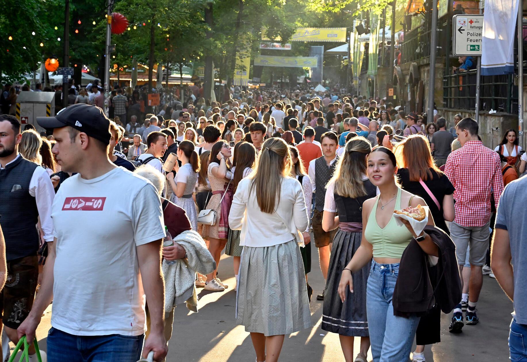 Erlangen: An Pfingstmontag pilgern nicht nut die Erlanger auf die Bergkirchweih zum Frühschoppen - Noch dazu, wenn die Sonne lacht. Die Besucher flanieren in der Abendsonne. Am frühen Abend strömt das Partyvolk auf den Berg und werden auf den Kellern mit entsprechender Musik versorgt. 20.5.2024. Foto: Harald Sippel