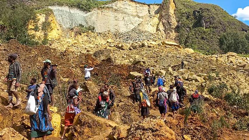 Dorfbewohner suchen in Yambali nach dem Erdrutsch nach Verschütteten.