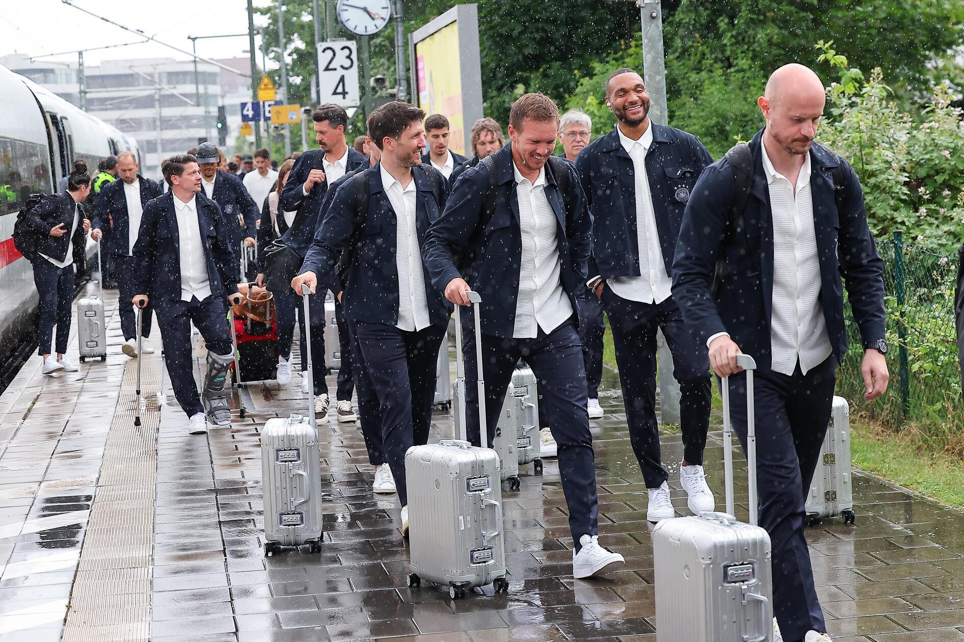 Bundestrainer Julian Nagelsmann (3.v.r.) und Spieler Jonathan Tah (2.v.r.) lassen sich die Laune auch durch das miese Wetter nicht verderben.
