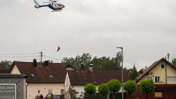 In Babenhausen im Unterallgäu wird ein Wasserretter aus einem Polizeihubschrauber abgeseilt. Nach den ergiebigen Regenfällen der letzten Tage gibt es Hochwasser in der Region. Neun bayerische Landkreise haben den Katastrophenfall inzwischen ausgerufen.