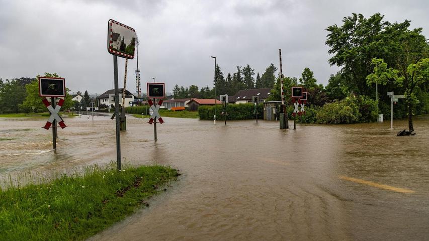 In Fischach im schwäbischen Landkreis Augsburg stehen seit Tagen eine Straße udn ein Bahnübergang unter Wasser. Foto: Hartl/vifogra/dpa