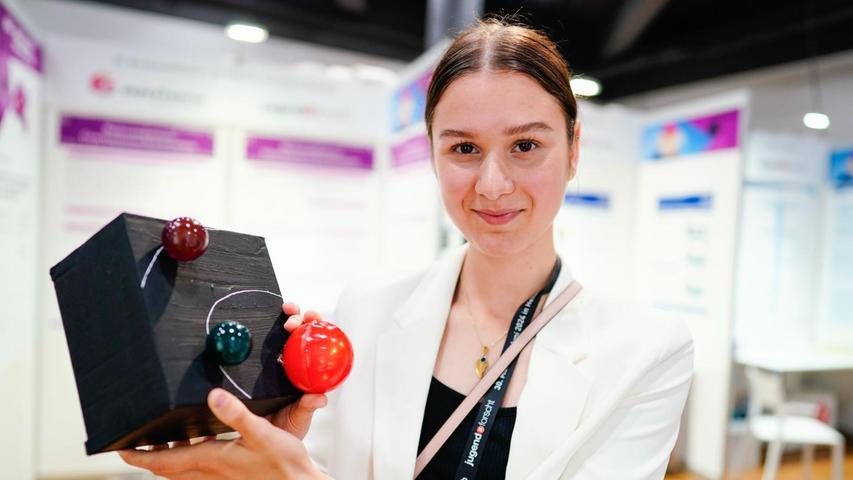 Anna Maria Weiß aus Berlin, Siegerin im Fachgebiet Geo- und Raumwissenschaften, hält das Modell eines von ihr erforschten Exoplaneten in den Händen.
