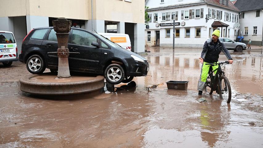 Auf einem Brunnen in Rudersberg steht ein durch Hochwasser weggespültes Auto.