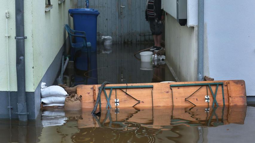 Ein Anwohner versucht in Burgau im Landkreis Günzburg, sein Haus vor dem Hochwasser zu schützen.