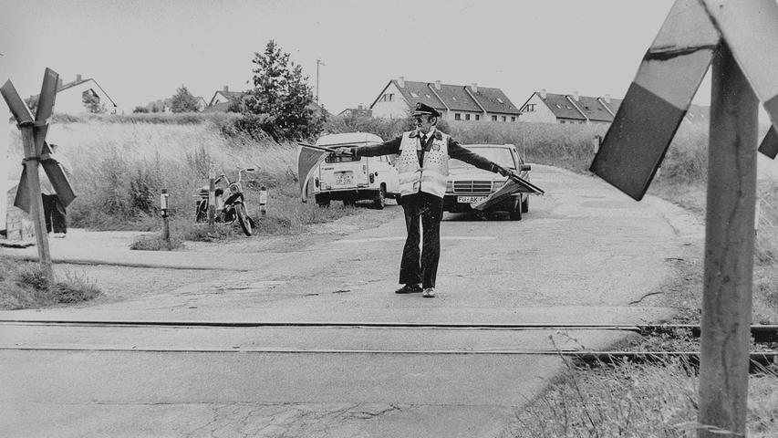 Mit rot-weißen Fähnchen und greller Signalweste gingen Bahnübergangswärter Toni K. und sein Kollege als die letzten Vertreter ihres Berufsstandes in Nordbayern im Jahre 1989 noch ihrer Arbeit nach. An zwei Bahnübergängen in Zirndorf verrichteten die beiden ihren Dienst. Kam gerade kein Zug, so warteten sie in kleinen Containern neben den Gleisen auf ihren nächsten Einsatz. Beschaulich war dieser Beruf nicht, denn oft musste Toni sich vor unvermittelt um die schlecht einsehbare Kurve fahrenden Autos mit einem Sprung zur Seite retten. Im Jahr 1992 war mit dem Umbau der Bahnübergänge diese Tätigkeit in der Region Geschichte. Mit rot-weißen Fähnchen und greller Signalweste gingen Bahnübergangswärter Toni K. und sein Kollege als die letzten Vertreter ihres Berufsstandes in Nordbayern im Jahre 1989 noch ihrer Arbeit nach. An zwei Bahnübergängen in Zirndorf verrichteten die beiden ihren Dienst. Kam gerade kein Zug, so warteten sie in kleinen Containern neben den Gleisen auf ihren nächsten Einsatz. Beschaulich war dieser Beruf nicht, denn oft musste Toni sich vor unvermittelt um die schlecht einsehbare Kurve fahrenden Autos mit einem Sprung zur Seite retten. Im Jahr 1992 war mit dem Umbau der Bahnübergänge diese Tätigkeit in der Region Geschichte.