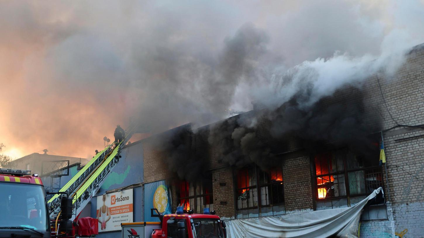 Ein Rettungshelfer löscht das Feuer in einem Lager für humanitäre Hilfe, das durch einen russischen Drohnenangriff in Saporischschja, Ukraine, zerstört wurde. Ein Rettungshelfer löscht das Feuer in einem Lager für humanitäre Hilfe, das durch einen russischen Drohnenangriff in Saporischschja, Ukraine, zerstört wurde.