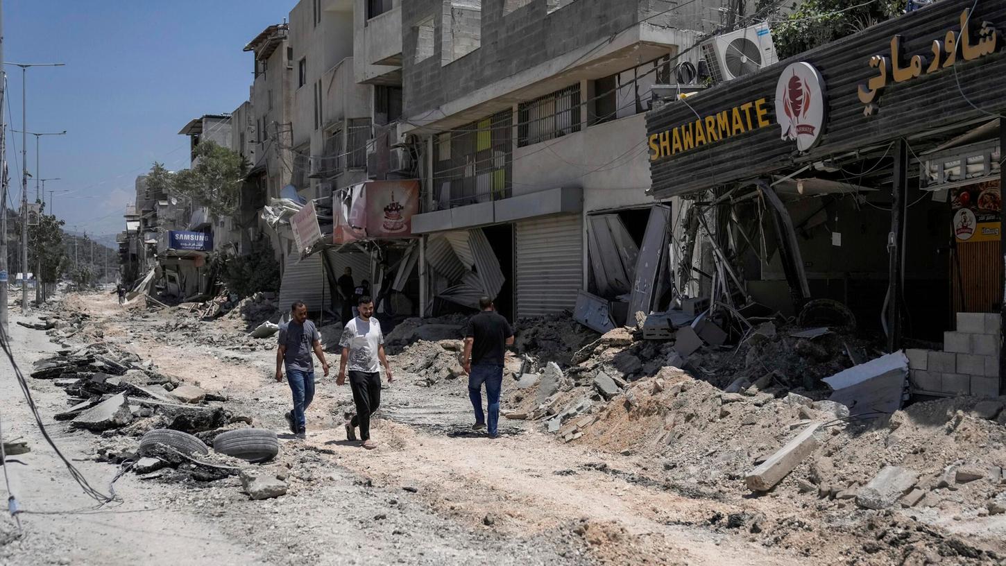 Palästinenser gehen nach einer israelischen Operation im Flüchtlingslager Nur Shams in der Nähe der Stadt Tulkarem im Westjordanland eine beschädigte Straße entlang.