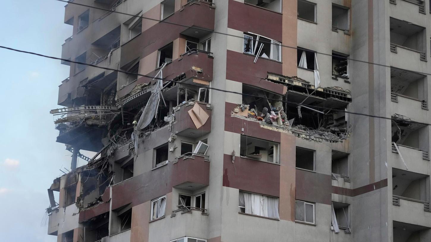 Feuerwehrleute arbeiten nach israelischen Angriffen am Ort einer Explosion in einer Wohnanlage im Norden von Teheran. Feuerwehrleute arbeiten nach israelischen Angriffen am Ort einer Explosion in einer Wohnanlage im Norden von Teheran.