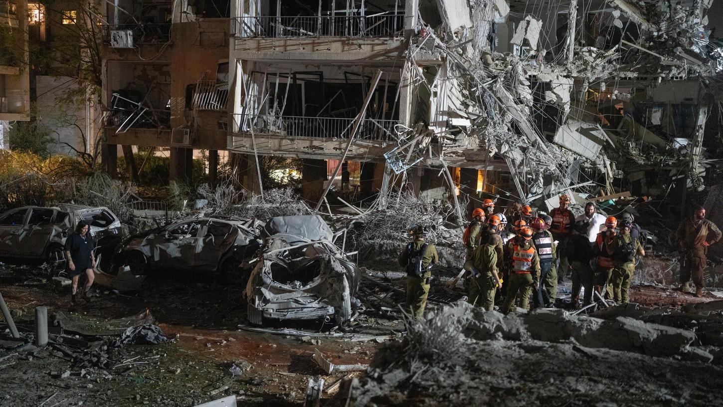 14.06.2025, Israel, Tel Aviv: Israelische Feuerwehrleute inspizieren die Schäden nach einem Raketeneinschlag in Ramat Gan in der Nähe von Tel Aviv. 14.06.2025, Israel, Tel Aviv: Israelische Feuerwehrleute inspizieren die Schäden nach einem Raketeneinschlag in Ramat Gan in der Nähe von Tel Aviv.