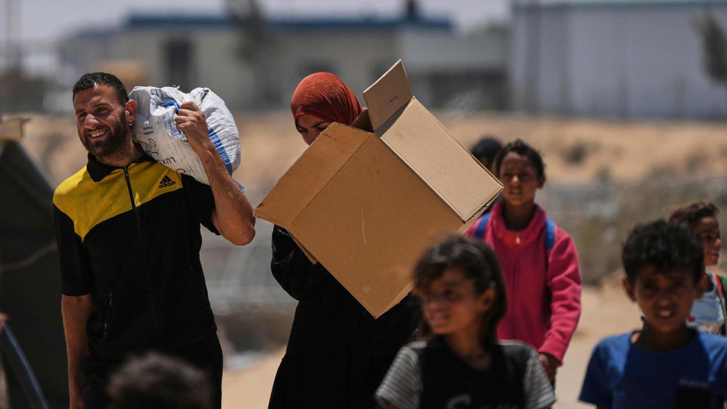 Palästinenser tragen Lebensmittel und humanitäre Hilfsgüter, die von der von den USA unterstützten Gaza Humanitarian Foundation geliefert wurden. Palästinenser tragen Lebensmittel und humanitäre Hilfsgüter, die von der von den USA unterstützten Gaza Humanitarian Foundation geliefert wurden.
