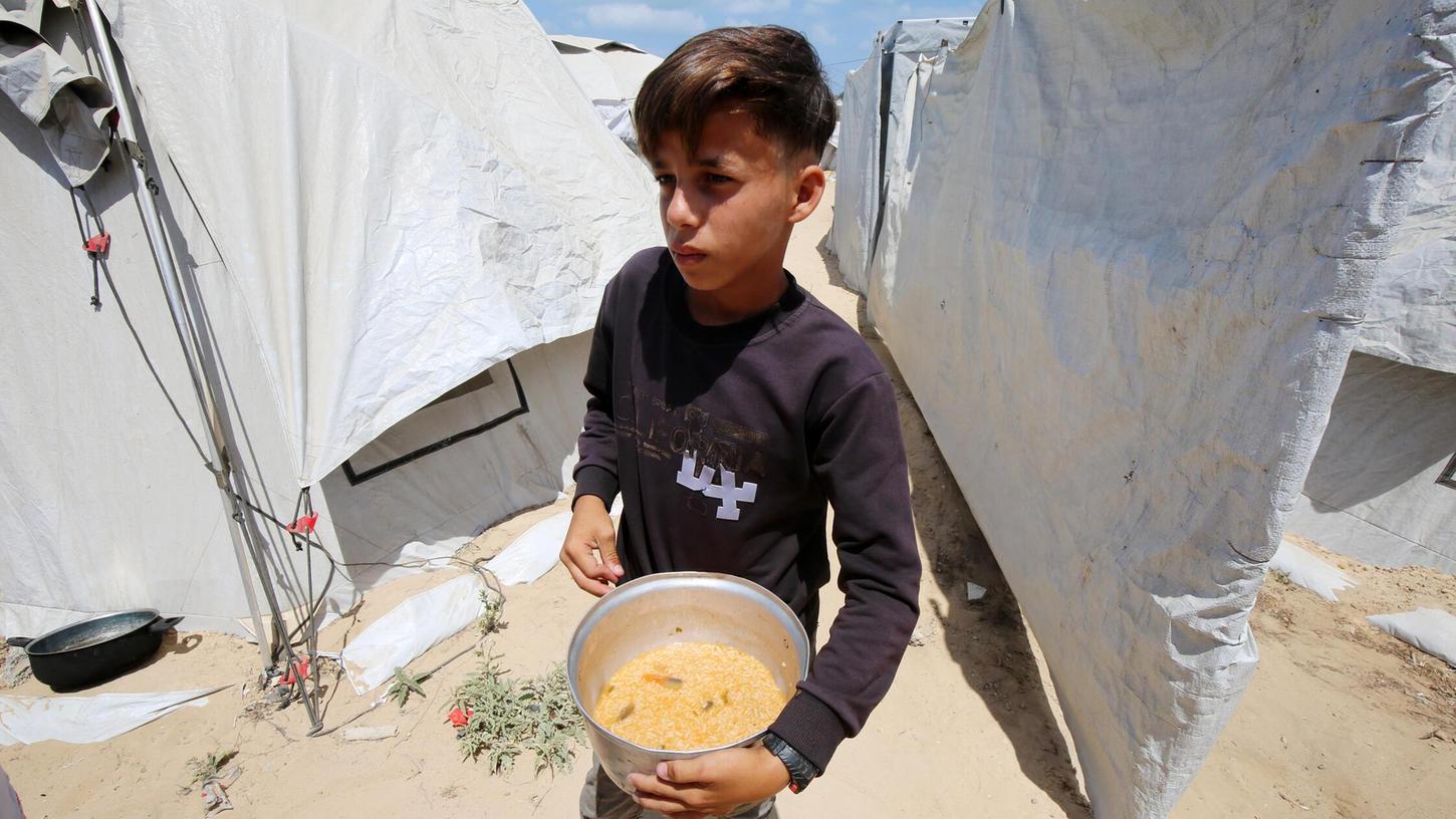 Wohltätigkeitsorganisationen verteilen warme Mahlzeiten an Palästinenser, die aufgrund der israelischen Angriffe auf den Gazastreifen und der geschlossenen Grenzen mit Hunger zu kämpfen haben. Wohltätigkeitsorganisationen verteilen warme Mahlzeiten an Palästinenser, die aufgrund der israelischen Angriffe auf den Gazastreifen und der geschlossenen Grenzen mit Hunger zu kämpfen haben.