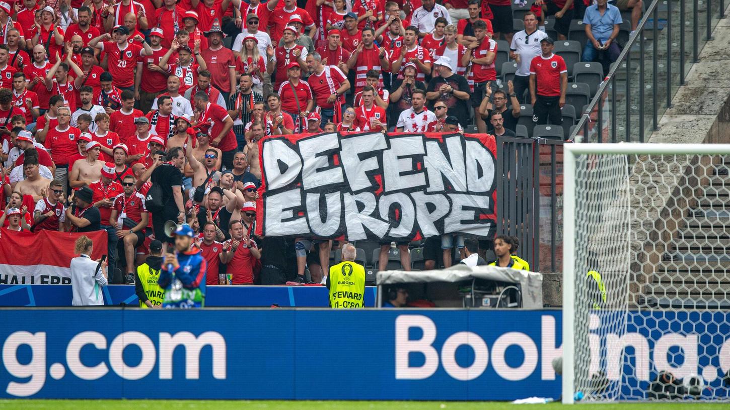 Österreichische Fans halten ein Banner mit einem Kampfslogan einer rechtsextremistischen Vereinigung hoch.