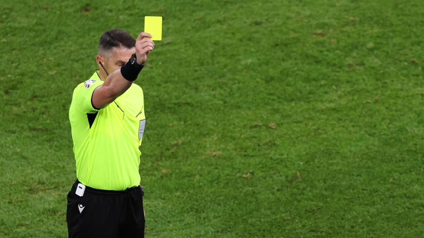 Schiedsrichter Istvan Kovacs zeigt bei der EM eine Gelbe Karte.