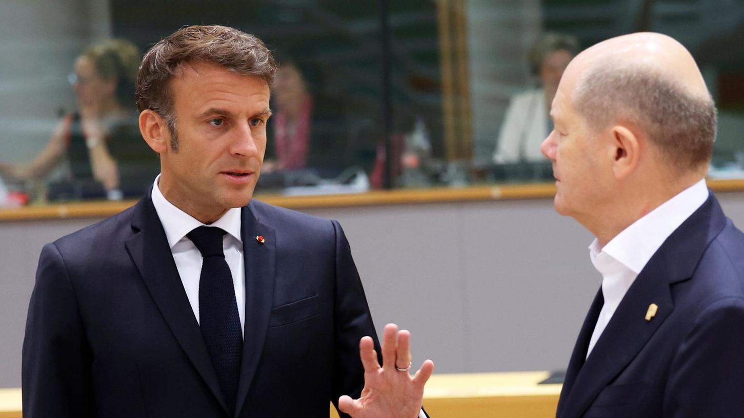 Emmanuel Macron (l), Präsident von Frankreich, spricht mit Bundeskanzler Olaf Scholz.