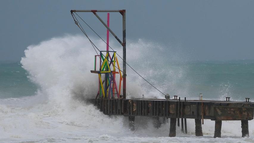 Wellen schlagen auf einen Pier, während der Hurrikan "Beryl" vorbeizieht.