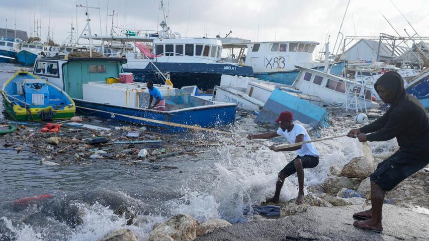 Fischer ziehen ein vom Hurrikan "Beryl" beschädigtes Boot zurück zu einem Dock.