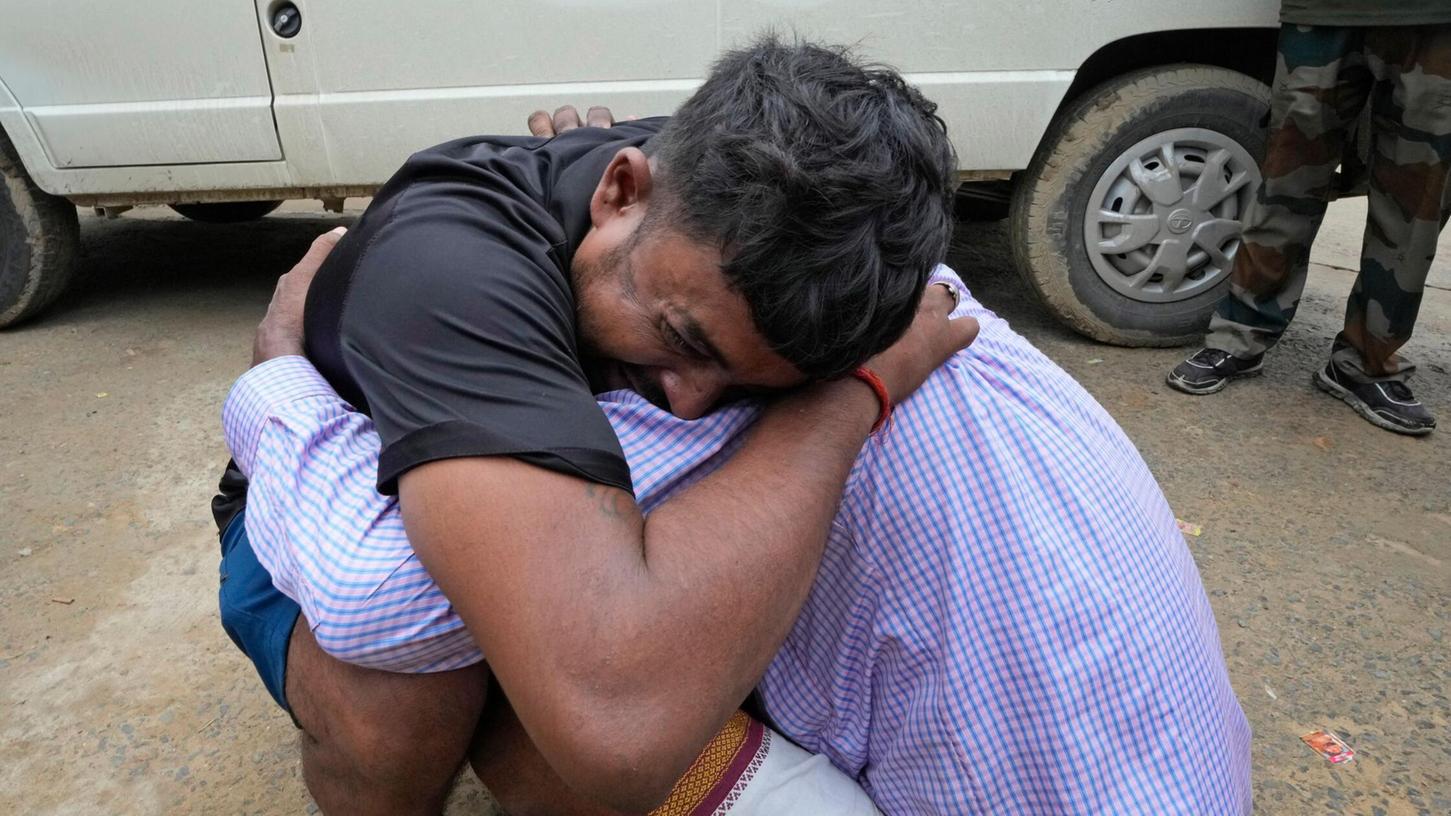 Ein Mann umarmt einen Angehörigen, nachdem seine Schwester Opfer der Massenpanik wurde.