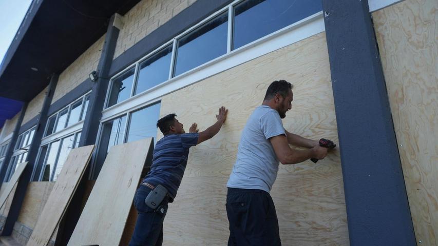 Mitarbeiter eines Möbelhauses in Mexiko verschalen die Fenster zum Schutz vor dem erwarteten Hurrikan "Beryl".