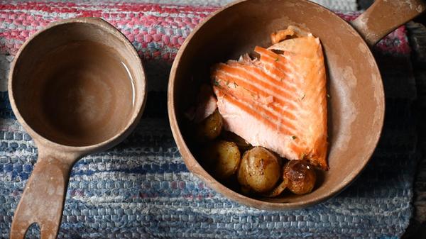 Frisch gefangen! Der Flammlachs landet direkt von der Feuerstelle in der traditionellen Holzschale. Auch die Kåsa, die Holztasse, darf nicht fehlen. Vor allem Weißfisch fangen sie hier, pro Saison und pro Fang-Brücke kommen schon 5000 Kilo pro Jahr zusammen.