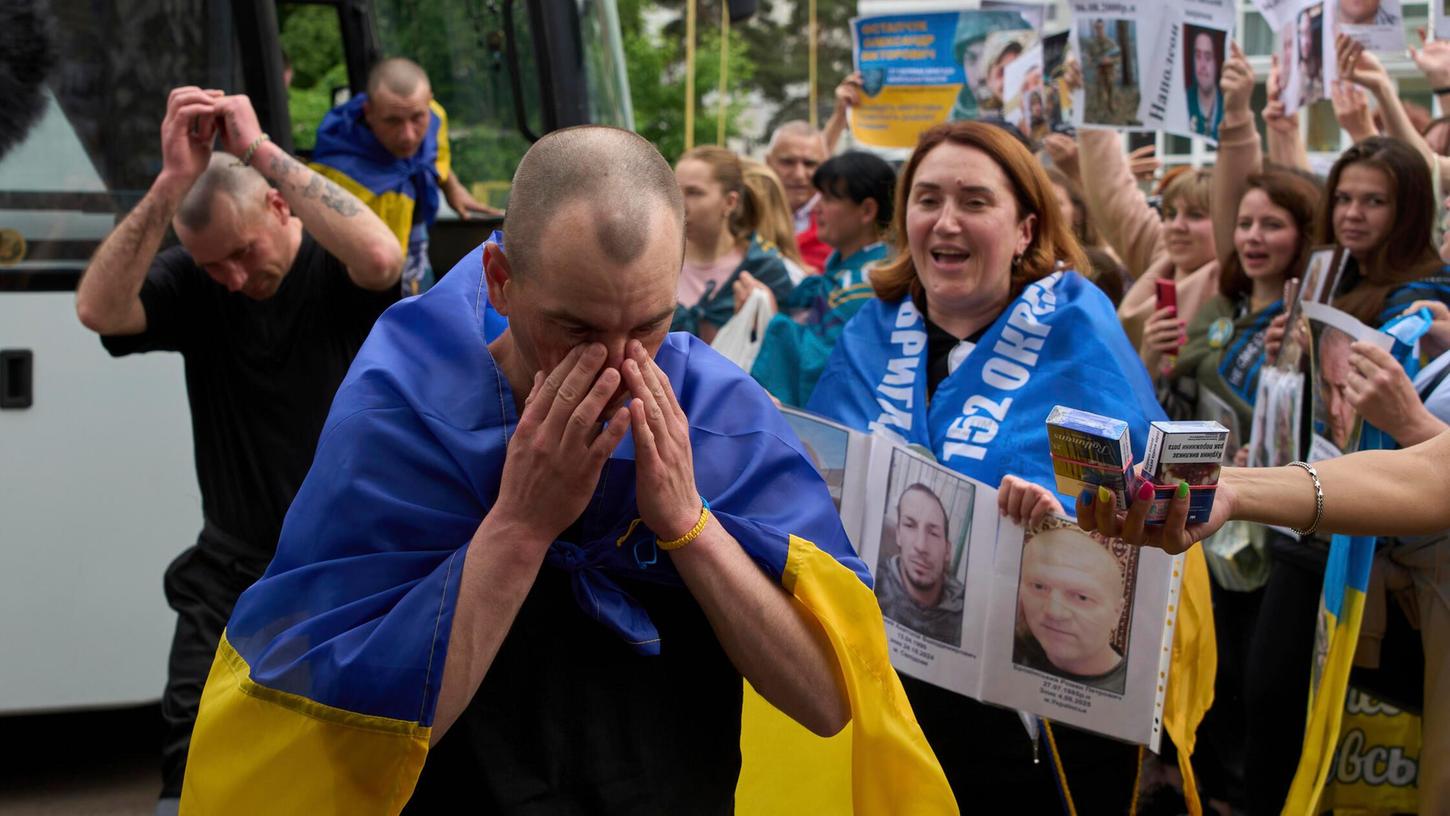 Menschen zeigen in der Region Tschernihiw Fotos von Soldaten in Gefangenschaft, als ukrainische Soldaten vorbeigehen, die im Rahmen eines Kriegsgefangenenaustauschs zwischen Russland und der Ukraine am Sonntag, 25. Mai 2025 aus der Gefangenschaft zurückgekehrt sind. Menschen zeigen in der Region Tschernihiw Fotos von Soldaten in Gefangenschaft, als ukrainische Soldaten vorbeigehen, die im Rahmen eines Kriegsgefangenenaustauschs zwischen Russland und der Ukraine am Sonntag, 25. Mai 2025 aus der Gefangenschaft zurückgekehrt sind.
