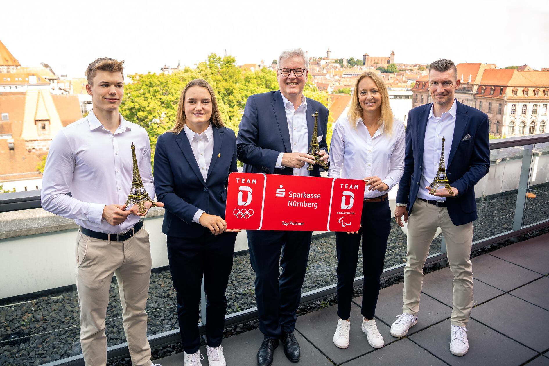 Die Sparkasse Nürnberg verabschiedete die Nürnberger Olympia- und Paralympics-Teilnehmer:innen bei einem Französischen Medien-Frühstück auf ihrer Dachterrasse in der Marienstraße (auf dem Bild v. l.): Paraschwimmer Taliso Engel, Bogenschützin Charline Schwarz, Sparkassen-Vorstandsvorsitzender Dr. Matthias Everding, Para-Triathletin Anja Renner und Paracycler Matthias Schindler freuen sich auf die Sommerspiel in Paris. Mit Ausnahme von Omid Ahmadi Safa (keine deutsche Staatsbürgerschaft) werden alle Olympia-Teilnehmer vom Verein "Goldener Ring" gefördert,