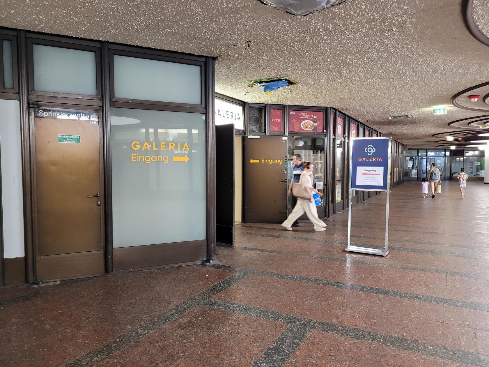 Direkt neben dem thailändischen Imbiss ist die andere Seite des Galeria-Ausgangs, um an die Fleischbrücke zu gelangen. Auf Nachfrage bei der Stadt Nürnberg heißt es: Die aktuelle Abbruchphase läuft nach Plan. Es gibt aktuell keinen Zeitverzug. Der erste Teilbereich der Haupthalle kann wie geplant Ende August wieder freigegeben werden. Die Abbrucharbeiten in der Haupthalle laufen weiter bis November. Der Durchgang ist weiterhin nicht möglich.