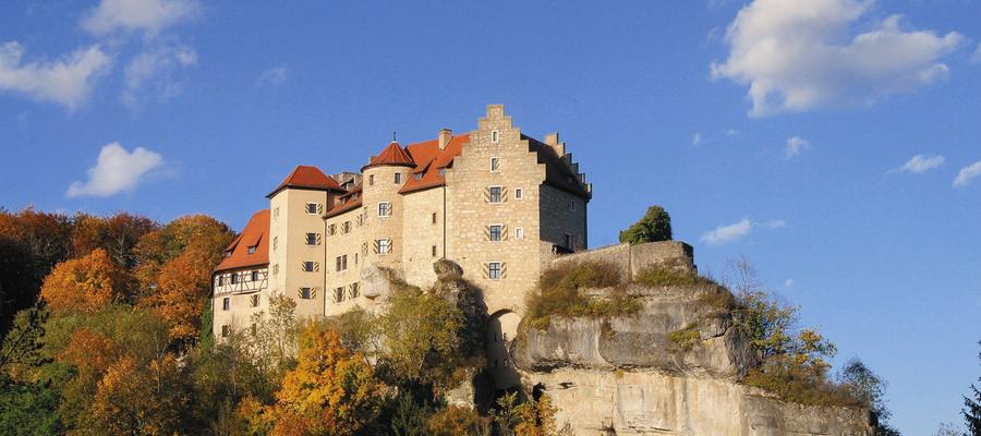 Auf einer in das Ailsbachtal hinaus­ragenden Felsspitze liegt die Burg Rabenstein . Täglich gibt es Führungen durch die alten Gemäuer. Auch die Flugvorführung der Falkerei ist ein echtes Highlight für die ganze Familie. Nähere Informationen zu aktuellen Führungen erhalten Sie hier .