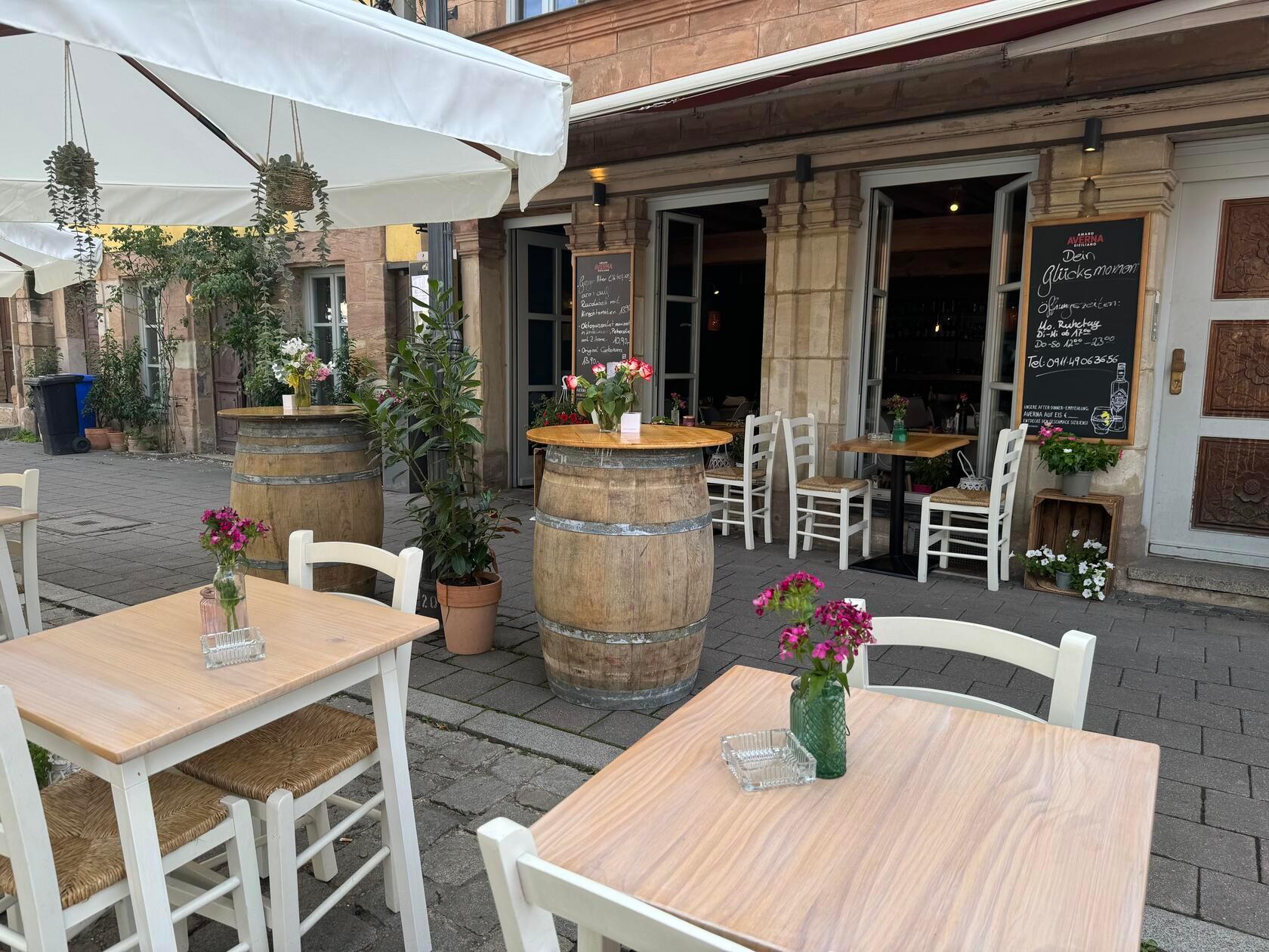 Der Außenbereich mit Fässern und floralem Schmuck.