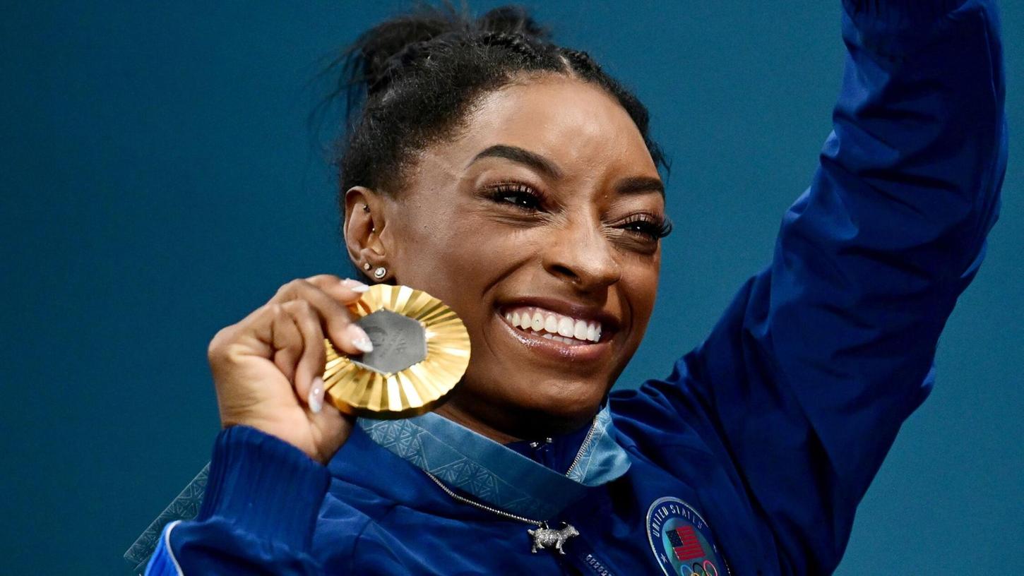Simone Biles zeigt stolz ihre sechste olympische Goldmedaille. Simone Biles zeigt stolz ihre sechste olympische Goldmedaille.