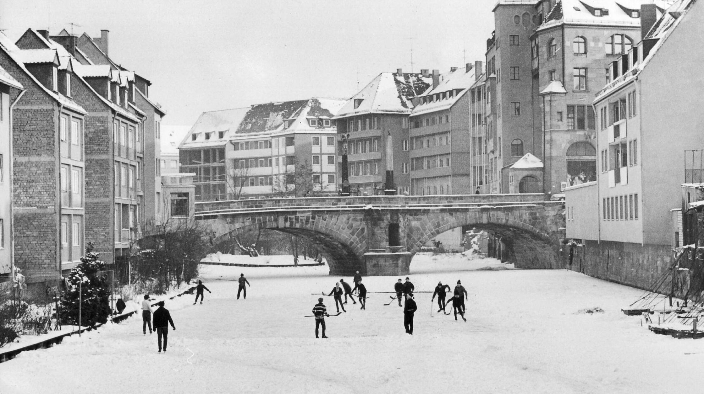 Mit minus 25 Grad war es im Januar 1963 so kalt in Nürnberg, dass Oberbürgermeister Andreas Urschlechter sich mit der Bitte um zusätzliche Heizöltransporte durch Bundeswehr und Bahn an das Wirtschaftsministerium wandte, um Versorgungsengpässe hinsichtlich der dringend benötigten Brennstoffe zu vermeiden. Während nicht wenige Menschen in der fränkischen Metropole unter der eisigen Kälte ächzten, wussten andere das Temperaturtief sportlich zu nutzen: So wurde nicht nur im Volkspark Marienberg eifrig gerodelt, mitten in der Altstadt trafen sich auf der zugefrorenen Pegnitz Jugendliche, um gemeinsam Eishockey zu spielen.