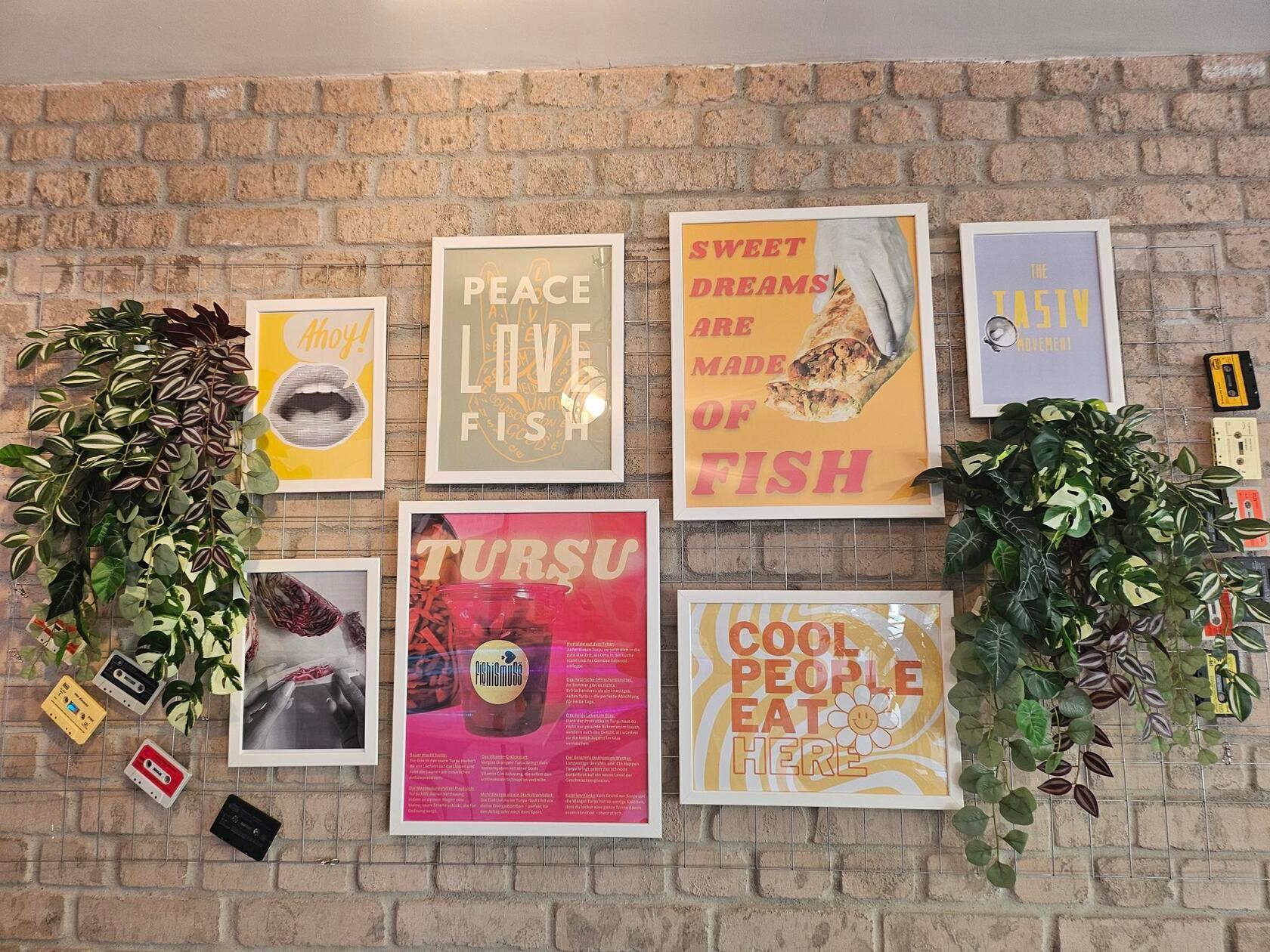 Viel Liebe zum Detail beweisen die Atlis auch bei der Deko. An den Wänden hängen verschiedene lustige Poster, auch auf ihnen dreht sich alles um die Fischgerichte im „Fishismuss“. Auf einem der Poster wird beispielsweise Rotkohl zu einem Joint eingerollt, auf einem anderen Poster steht „Peace, Love, Fish“.