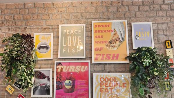 Viel Liebe zum Detail beweisen die Atlis auch bei der Deko. An den Wänden hängen verschiedene lustige Poster, auch auf ihnen dreht sich alles um die Fischgerichte im „Fishismuss“. Auf einem der Poster wird beispielsweise Rotkohl zu einem Joint eingerollt, auf einem anderen Poster steht „Peace, Love, Fish“.