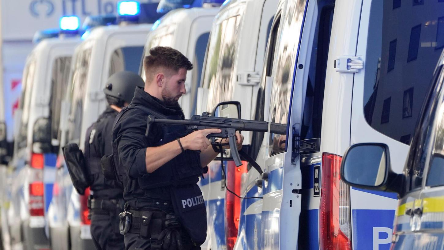 Polizisten sind in München im Einsatz und stehen an ihren Autos. Polizisten sind in München im Einsatz und stehen an ihren Autos.