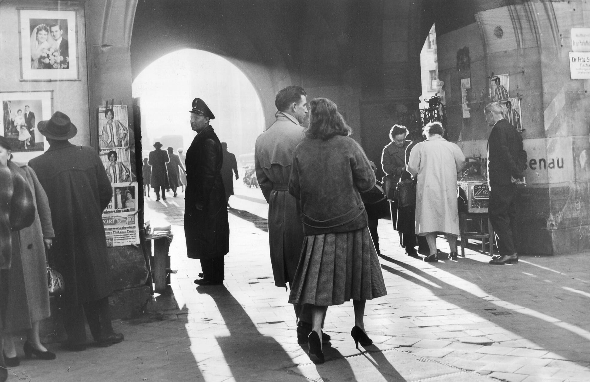 „Ein bisschen Klein-Paris, ein Stückchen Alltag und darüber jene melancholische Stimmung gebreitet, die dem Herbst so eigen ist. (…) - Ja, man braucht nur hineinzuschauen in sein Nürnberg – es ist schon schön.“, so lautete die überschwängliche Bildunterschrift in den NN zu dem 1957 entstandenen Motiv. In dieser Szenerie treffen sich Alltag und Poesie: ein Schutzmann und ein Liebespaar, ein Verkäufer, der seine Waren anbietet und ein Herr, der Schaukästen mit Hochzeitspaaren betrachtet, beleuchtet von der Herbstsonne, die durch das Tor am Weißen Turm fällt. 1978 wurde dort die U-Bahn-Station gleichen Namens eröffnet.
