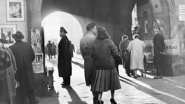 „Ein bisschen Klein-Paris, ein Stückchen Alltag und darüber jene melancholische Stimmung gebreitet, die dem Herbst so eigen ist. (…) - Ja, man braucht nur hineinzuschauen in sein Nürnberg – es ist schon schön.“, so lautete die überschwängliche Bildunterschrift in den NN zu dem 1957 entstandenen Motiv. In dieser Szenerie treffen sich Alltag und Poesie: ein Schutzmann und ein Liebespaar, ein Verkäufer, der seine Waren anbietet und ein Herr, der Schaukästen mit Hochzeitspaaren betrachtet, beleuchtet von der Herbstsonne, die durch das Tor am Weißen Turm fällt. 1978 wurde dort die U-Bahn-Station gleichen Namens eröffnet.