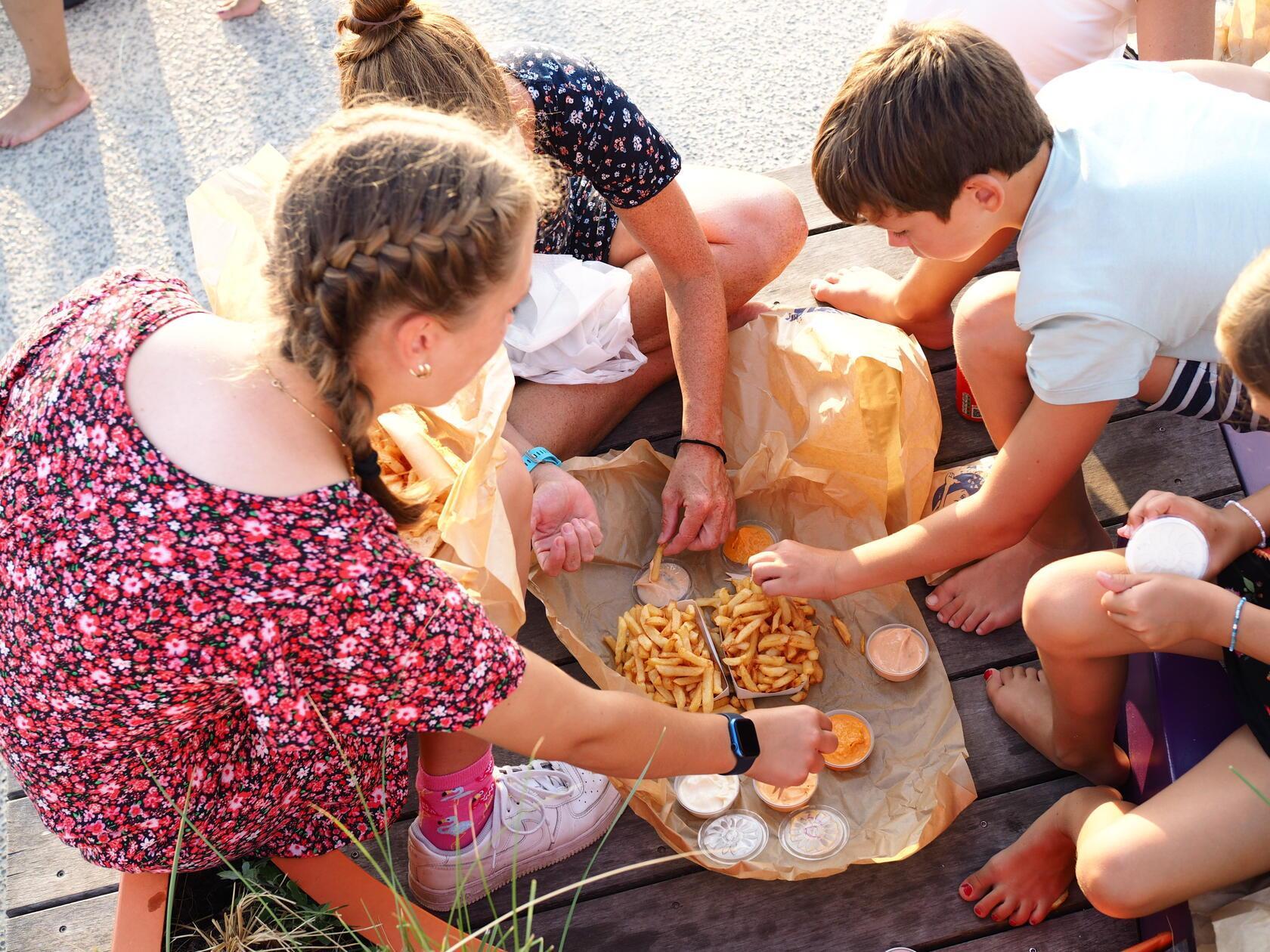 Noch auf der Strandpromenade verputzen wir die Fritten mit verschiedenen Saucen und Sandwiches.