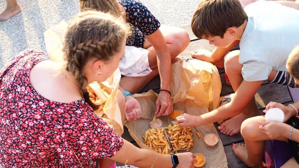 Noch auf der Strandpromenade verputzen wir die Fritten mit verschiedenen Saucen und Sandwiches.