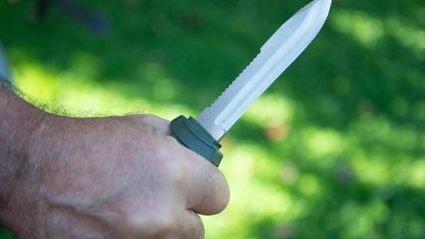 Eine Hand hält ein Messer in bedrohlicher Weise. (Symbolbild) Eine Hand hält ein Messer in bedrohlicher Weise. (Symbolbild)