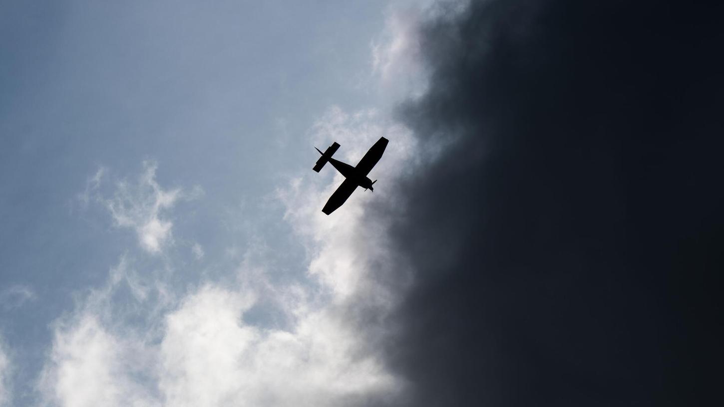 Ein Kleinflugzeug fliegt vor dunklen Wolken. (Symbolbild) Ein Kleinflugzeug fliegt vor dunklen Wolken. (Symbolbild)