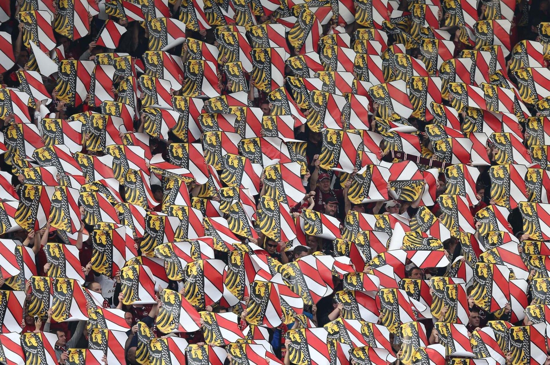 Schön immerhin aus Nürnberger Sicht: das Nürnberger Stadtwappen strahlt oberhalb der rot-schwarzen Spielwiese mit der Frühlingssonne tausendfach um die Wette.
