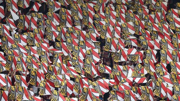 Schön immerhin aus Nürnberger Sicht: das Nürnberger Stadtwappen strahlt oberhalb der rot-schwarzen Spielwiese mit der Frühlingssonne tausendfach um die Wette.